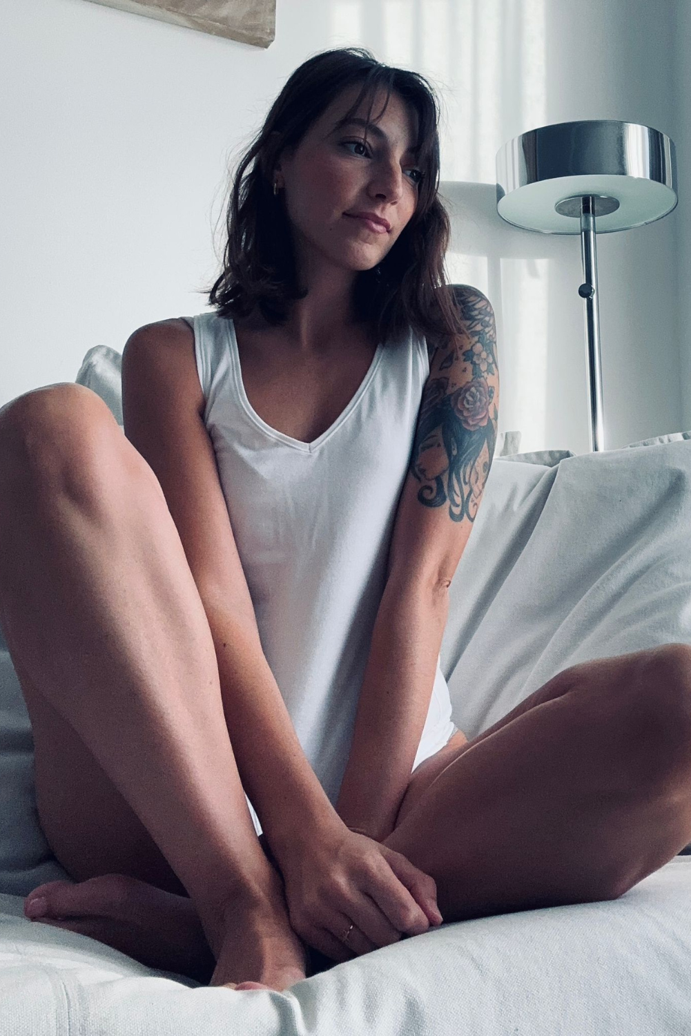 Camiseta sin mangas de algodón orgánico GOTS blanca Udhara con modelo sentada